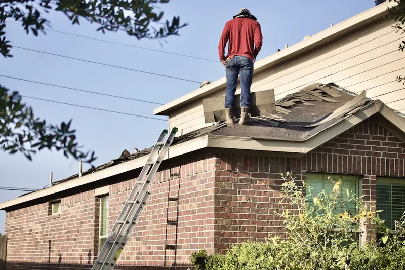 Professional roofer working on a residential roof in Clymer